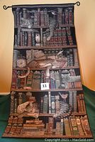 Full view of the tapestry showing cats on bookshelves with the hanging rod visible at top.