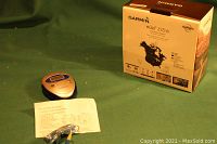 Photo of Garmin nuvi 255W box, manual, and accessory cable laid out on green background.