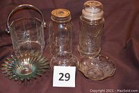 Full view of the six glass items on a purple cloth background with identification card #29 in front. Includes the peanut jar with lid, small round vase, candy dish, sunburst dish, glass ice bucket with silver handle, and Kerr quart canning jar without ring.