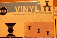 Photo showing Wallies brand vinyl kit packaging with black vase-shaped patterns and applicator tool illustrated.
