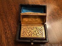 Open vinaigrette inside its leather case showing gilt interior and pierced lid design
