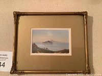 Framed miniature oil painting showing full view of seascape, islands, boats, coastal terrain, and gold ornate frame.