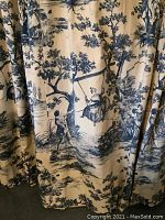 Detail of toile fabric pattern showing pastoral scene with figures and trees.