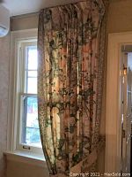 Single curtain panel hung on window frontal view showing full length pattern and border trim.