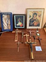 Eight crucifixes, small statue on base, green holy card plaque, framed icons, boxed crucifix arranged on table