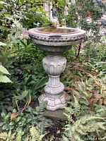 Front view of entire birdbath showing basin, pedestal and base in garden setting