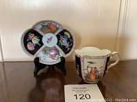 Front view of saucer on stand with cup to right showing overall design and color scheme