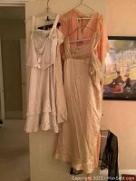 All five garments displayed on hangers against door