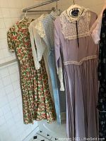 All four dresses and one jacket hanging on rod