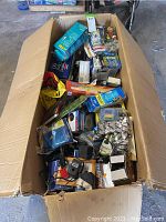 Large box containing assorted aquarium supplies including filters, pumps, and packaged items.