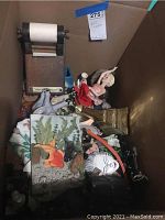 View into box showing various home decor items including wooden tape dispenser and fish painting