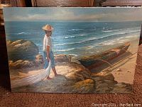 Photo of original landscape painting with man holding fishing net standing on sandy rocks near ocean and boat