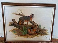 Front view of the framed oil painting showing two foxes by a fallen tree with signature.