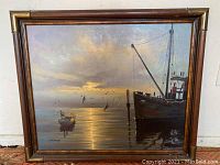 Frontal view of the framed oil painting depicting boats on water at sunset.