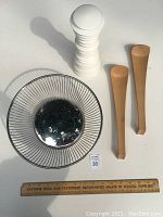 Metal wire basket bowl with white salt/pepper mill and wooden salad servers