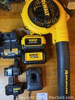 Top view showing yellow Dewalt XR 40V brushless leaf blower, two 40V batteries, two 14.4V batteries and charger