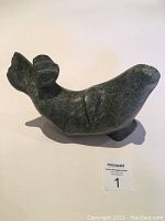 Front-left angled view of the dark greenish-gray stone seal carving showing the form and silhouette.