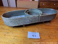 Photo showing assembled bowls with speckled green glaze and feet on a wooden table