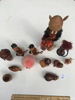 Overhead photo showing the full assortment of 12 wooden figures and accessories including the Viking, guitar players, pink fuzzy figure, and other small pieces spread out on a white surface.