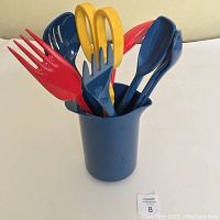 Set of 8 cooking utensils in blue container showing colorful utensils protruding.