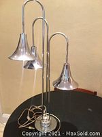 Front view of lamp showing three chrome trumpet-shaped shades and circular base