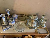 Wide view of the lot showing the dresser sets, candle sticks, porcelain boxes, ashtrays and tray