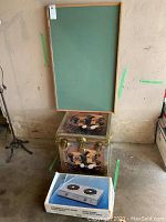 Lot items stacked: green framed chalkboard, dog painted trunk, and a double burner electric range box.