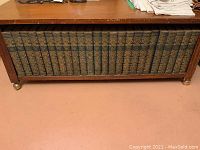 Front view of 24 volumes of the 1929 Encyclopedia Britannica tightly arranged in the wooden bench.