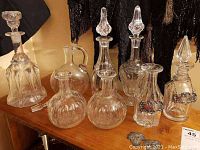 Group view of all glass decanters showing variety in shape, stopper style, and etched/pressed glass.