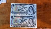 Two 1973 Canadian one dollar bills with visible sequential serial numbers and Queen Elizabeth II portrait.
