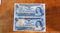 Two 1973 Canadian one dollar bills laid side by side on a wooden surface. Both show the front face featuring Queen Elizabeth II and the Canadian coat of arms.