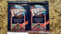 Two unopened 1991 Upper Deck NFL Football 1991 High Series trading card packs in blue foil packaging.