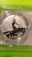 Close-up of the coin showing a person jumping on the front face with text '20 dollars', '2014', 'Canada' and 'fine silver argent pur 9999'.