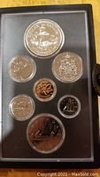View of all 7 coins displayed in protective holder showing varied Canadian themed designs, including Griffon ship, maple leaf, loon, and wildlife.