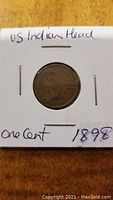 Obverse of 1898 US Indian Head one cent coin in a white cardboard holder with handwritten notes.