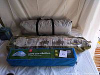 Three camping tents in carry bags arranged on table showing different bag colors and labels