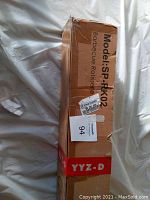 Photo of the long cardboard box labeled Model: SP-RK02 Barbecue Rotisserie. Box shows light wear.