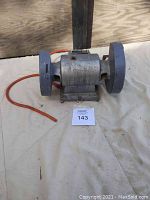 Front view of bench grinder with both grinding wheels visible and cut power cable.