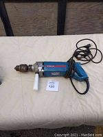 Overall front view of heavy duty Bosch electric drill with cord and handle, showing blue body and chuck.