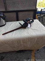 Full view of the Craftsman electric hedge trimmer on a white cloth background, showing the blade and overall unit condition.