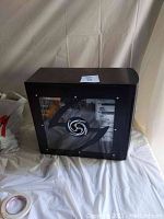 Front and left side view of black and red mid-tower case with side panel window and LED fan visible