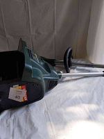 Side view of Yardworks green electric snowblower showing control handle and chute.