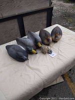Five floating duck decoys arranged in a row, showing all attached ropes and weights for anchoring purposes.