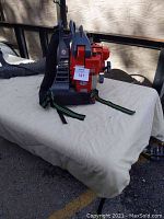 Side view of red Efco backpack leaf blower showing engine housing and harness