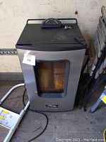 Closed view of Masterbuilt electric smoker showing glass door, control panel on top, and overall condition.