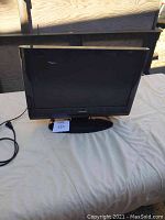 Front view of a small Toshiba flat screen TV on stand, showing screen and Toshiba branding.