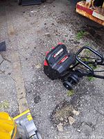 Full view of the electric snowblower showing handle and red rotating auger.