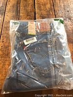 Photo of Levi’s 511 Slim Fit jeans folded inside clear plastic packaging showing back pockets, Levi's patch, and size label.