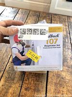 Hand holding original box of Zellbuck 107 respirator set with image showing person wearing the respirator and mask, box placed on wood surface.