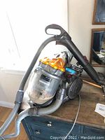 Front view of Dyson vacuum showing cyclone drum, hose and wand